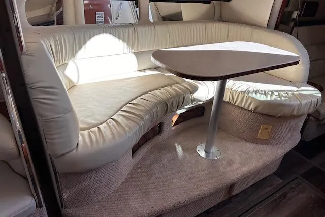 Slide: The Image of 2002 Sea Ray 340 Sundancer interior with cream leather seating and a wooden table. - 35
