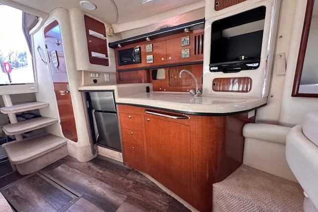 Slide: The Image of 2002 Sea Ray 340 Sundancer interior with kitchenette, wood cabinetry, and modern appliances. - 39