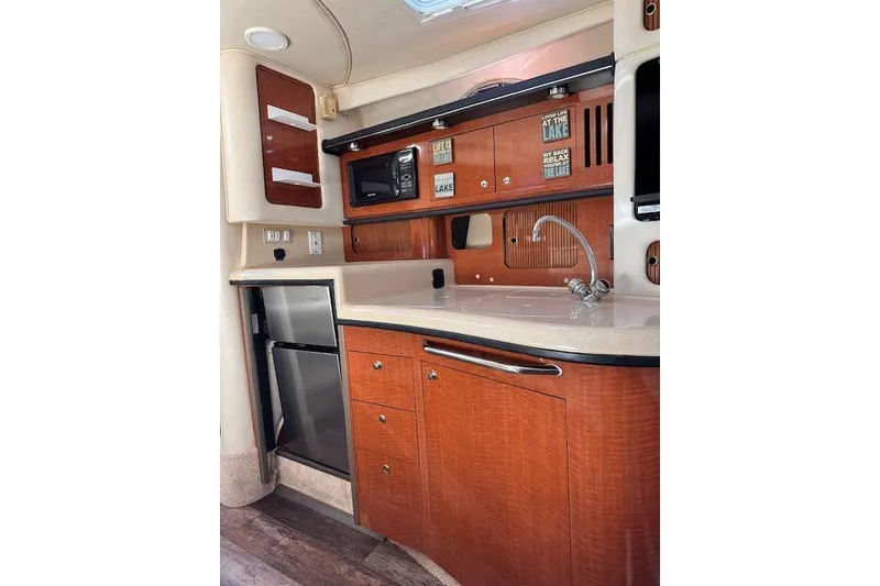 Slide: The Image of 2002 Sea Ray 340 Sundancer interior kitchen with wood cabinetry, sink, and appliances. - 40