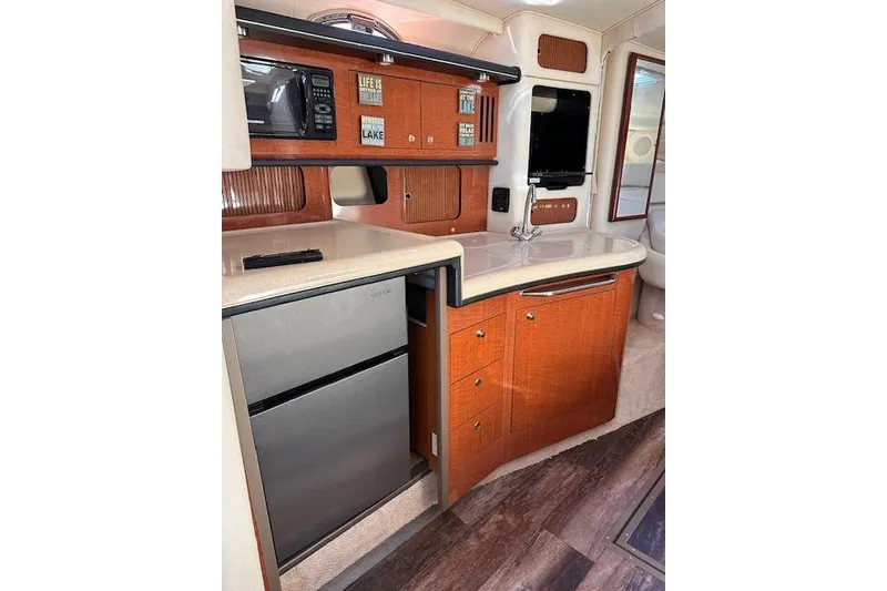 Slide: The Image of 2002 Sea Ray 340 Sundancer interior kitchen with wood cabinetry and modern appliances. - 43
