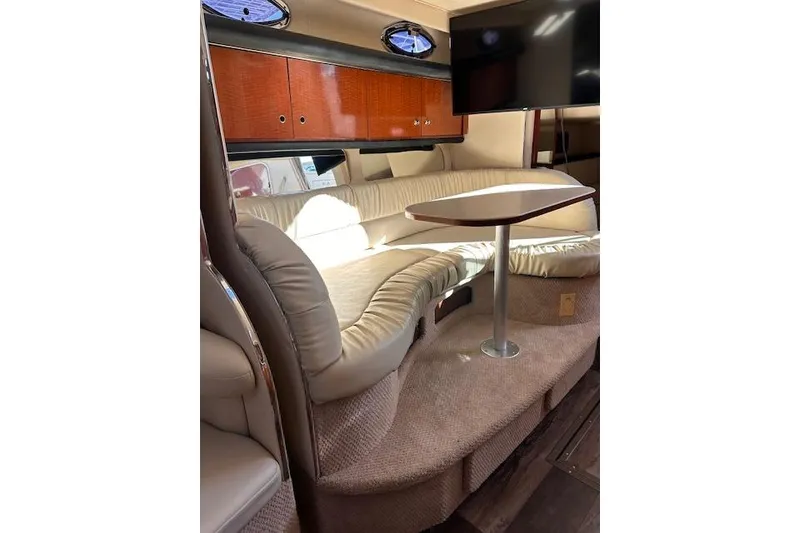 Slide: The Image of Interior of 2002 Sea Ray 340 Sundancer with plush seating and a mounted TV. - 44