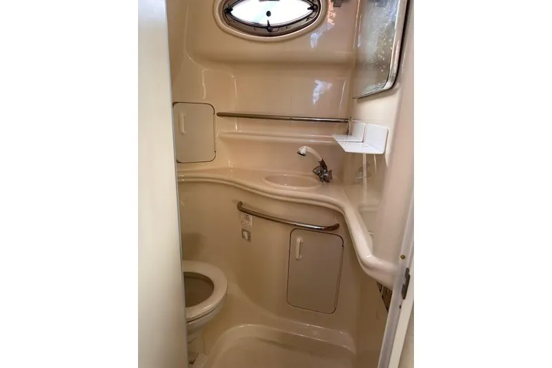 Slide: The Image of 2002 Sea Ray 340 Sundancer bathroom with sink, toilet, and porthole window. - 45
