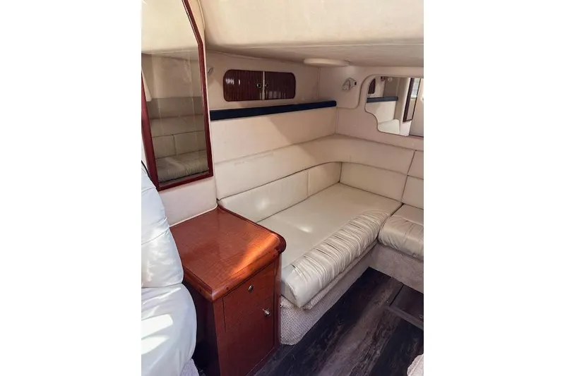 Slide: The Image of Interior of 2002 Sea Ray 340 Sundancer with cream seating and wooden cabinetry. - 52
