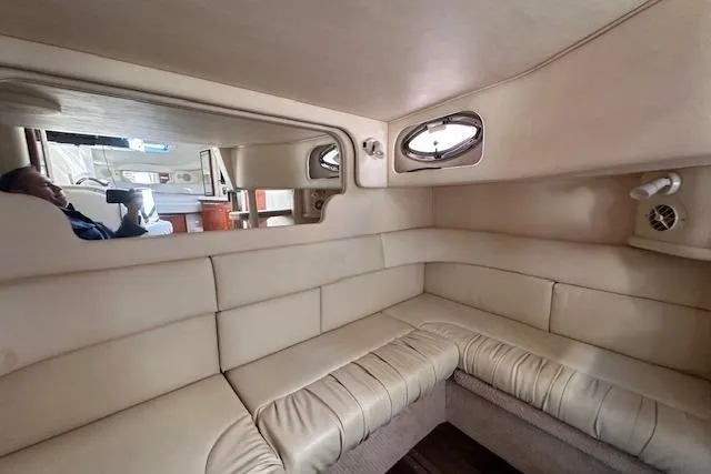 Slide: The Image of Interior of 2002 Sea Ray 340 Sundancer yacht with beige leather seating and porthole windows. - 57