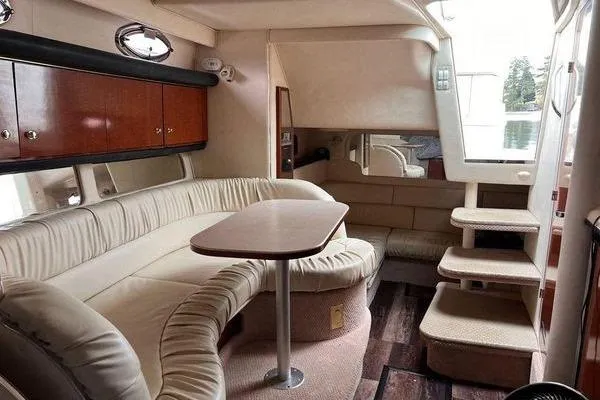 Slide: The Image of Interior of 2002 Sea Ray 340 Sundancer yacht with plush seating and wooden cabinetry. - 68