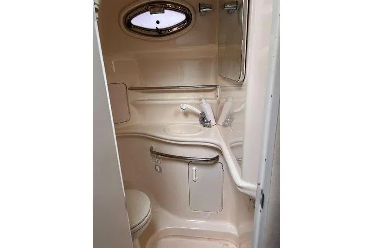 Slide: The Image of 2002 Sea Ray 340 Sundancer bathroom with sink, toilet, and oval window. - 73