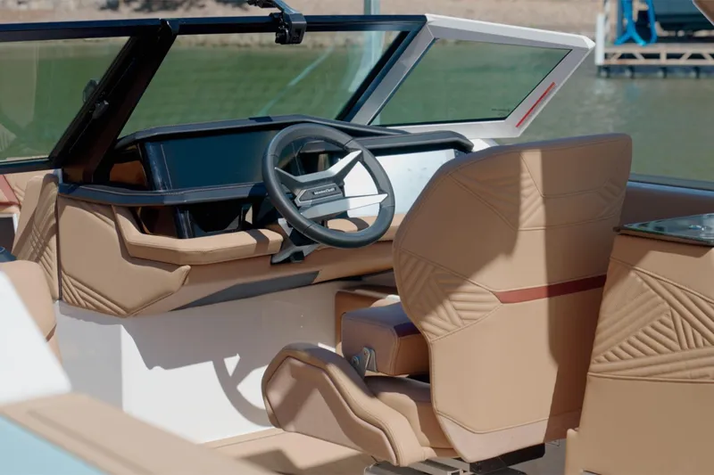 Slide: The Image of 2025 MasterCraft XStar 25 boat interior with tan leather seats and modern dashboard. - 16