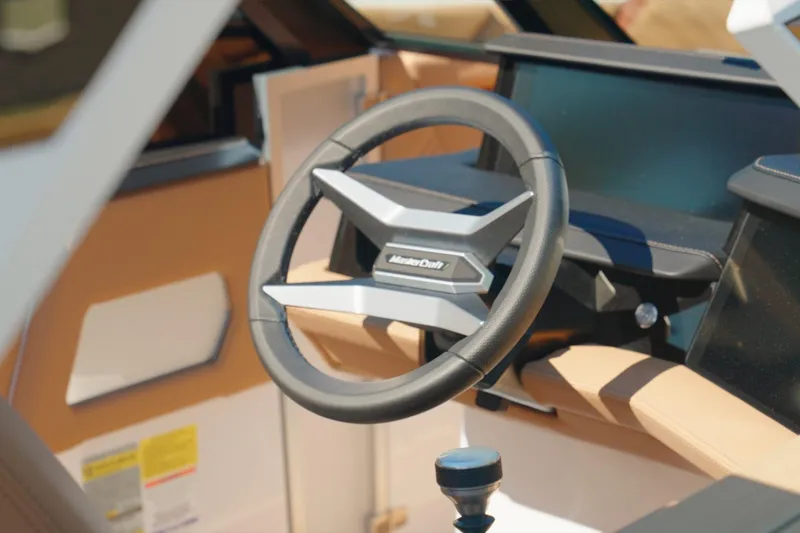 Slide: The Image of Steering wheel of 2025 MasterCraft XStar 25 boat, featuring modern design and controls. - 2
