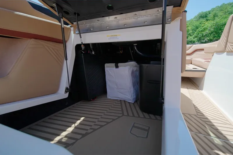 Slide: The Image of Interior storage compartment of 2025 MasterCraft XStar 25 boat, featuring seating and storage space. - 21
