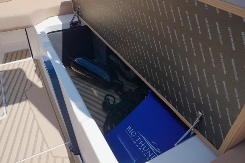 Slide: The Image of Open storage compartment in 2025 MasterCraft XStar 25 boat, featuring marine equipment. - 23