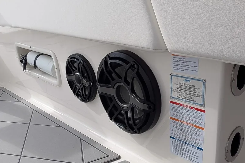 Slide: The Image of 2023 Robalo 266 Cayman boat interior with speakers and safety certification labels. - 16