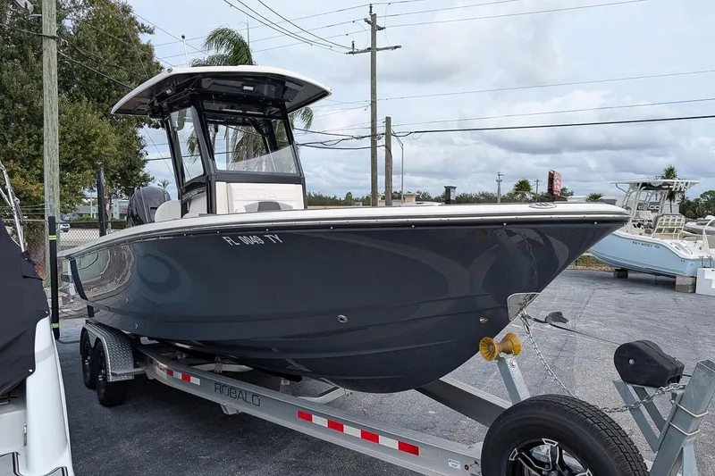 Slide: The Image of 2023 Robalo 266 Cayman boat on trailer, parked outdoors, side view. - 2