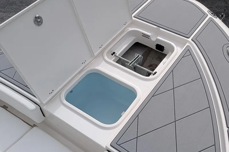 Slide: The Image of 2023 Robalo 266 Cayman boat storage compartment with open hatch and water-filled livewell. - 21