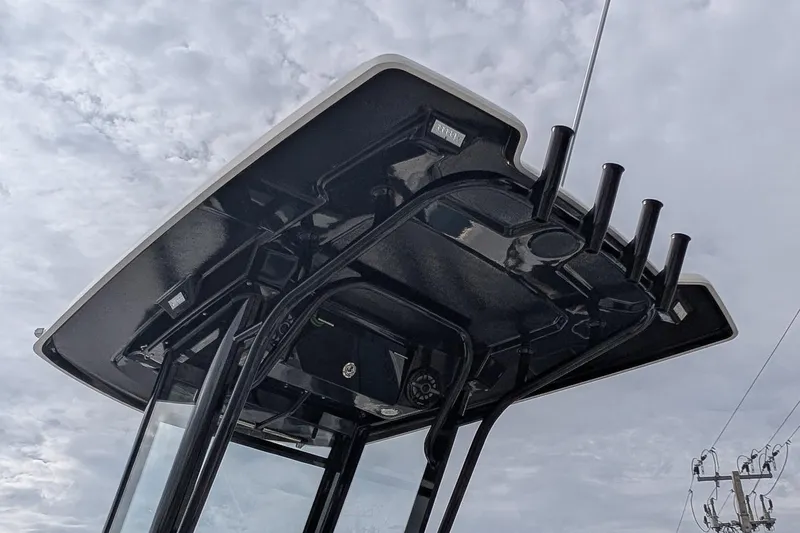 Slide: The Image of 2023 Robalo 266 Cayman T-top with rod holders against cloudy sky. - 22