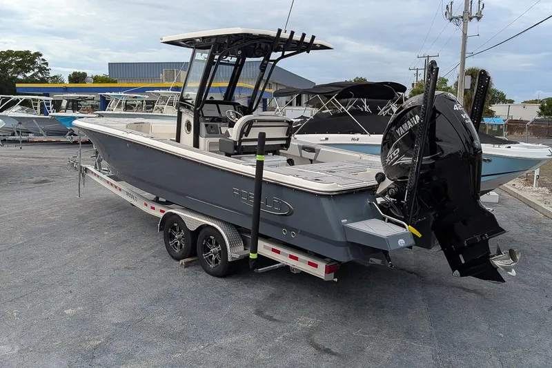 Slide: The Image of 2023 Robalo 266 Cayman boat on trailer with Yamaha engine, parked in a marina. - 3