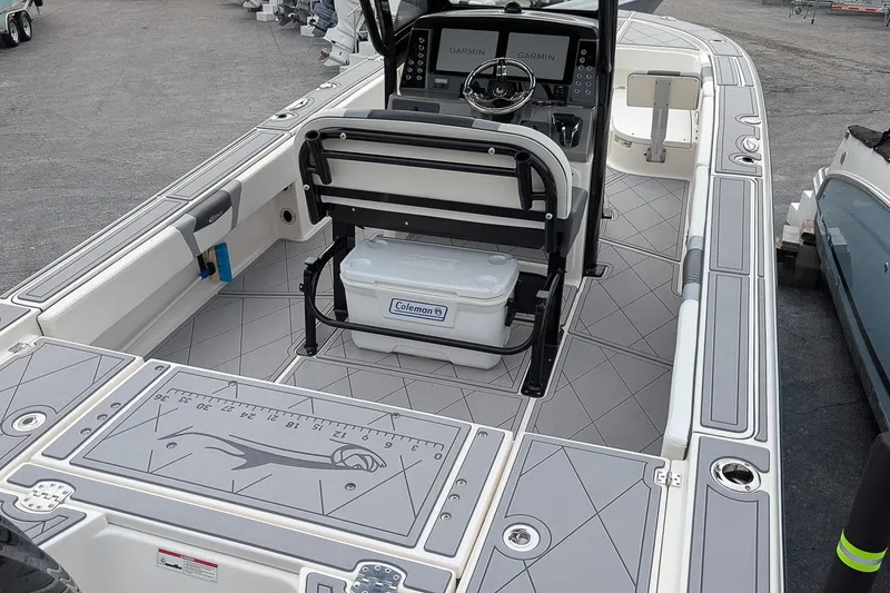 Slide: The Image of 2023 Robalo 266 Cayman boat interior with Garmin displays and Coleman cooler. - 7