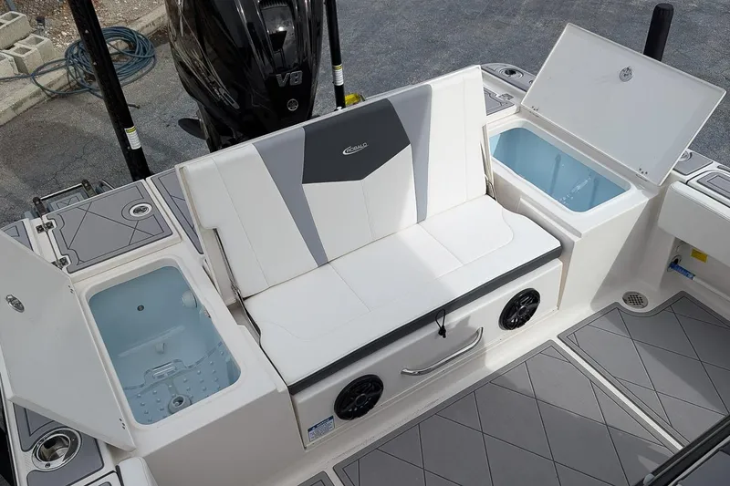Slide: The Image of 2023 Robalo 266 Cayman boat interior with seating, storage compartments, and V8 engine. - 9