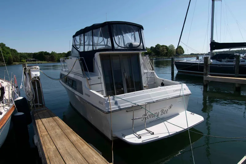 Slide: The Image of 1995 Carver 330 Mariner docked at a marina, named "Honey Bee." - 2
