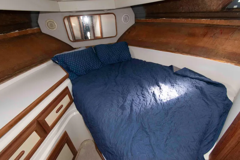 Slide: The Image of Cozy cabin interior of 1995 Carver 330 Mariner with blue bedding and wooden accents. - 6