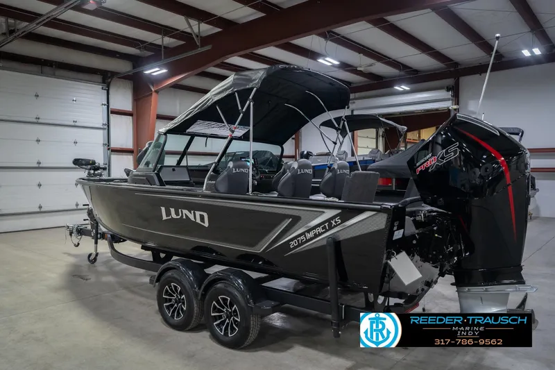 Slide: The Image of 2026 Lund 2075 Impact XS boat in showroom, featuring sleek design and modern features. - 10