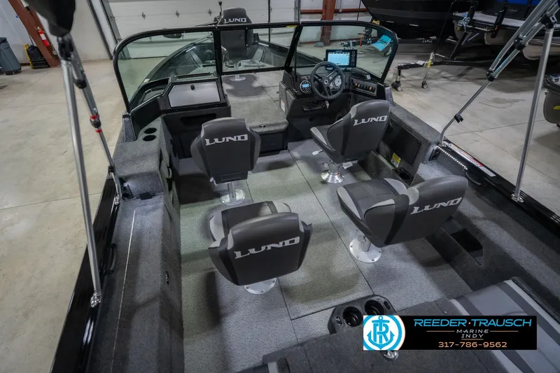 Slide: The Image of 2026 Lund 2075 Impact XS boat interior with seating and dashboard, displayed in a showroom. - 15