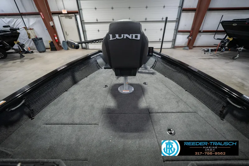 Slide: The Image of 2026 Lund 2075 Impact XS boat interior in showroom, featuring spacious deck and seating. - 18