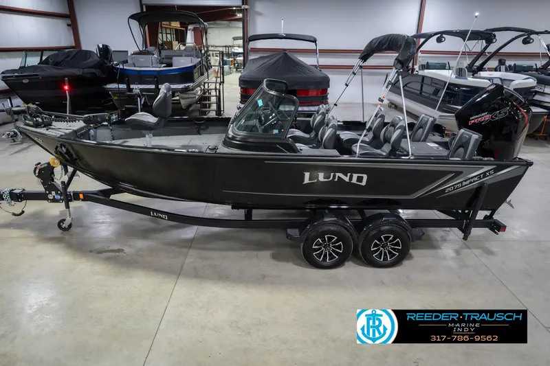 The Image of 2026 Lund 2075 Impact XS boat in showroom, side view, on trailer. - 2
