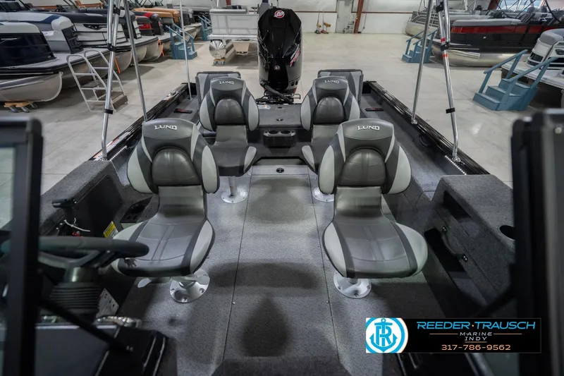 Slide: The Image of 2026 Lund 2075 Impact XS boat interior with four gray seats in a showroom. - 20