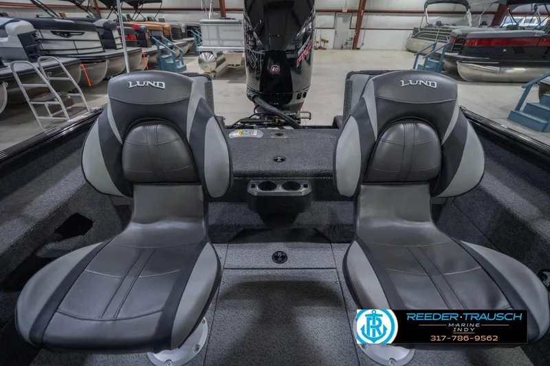 Slide: The Image of 2026 Lund 2075 Impact XS boat interior with two gray seats in a showroom. - 21