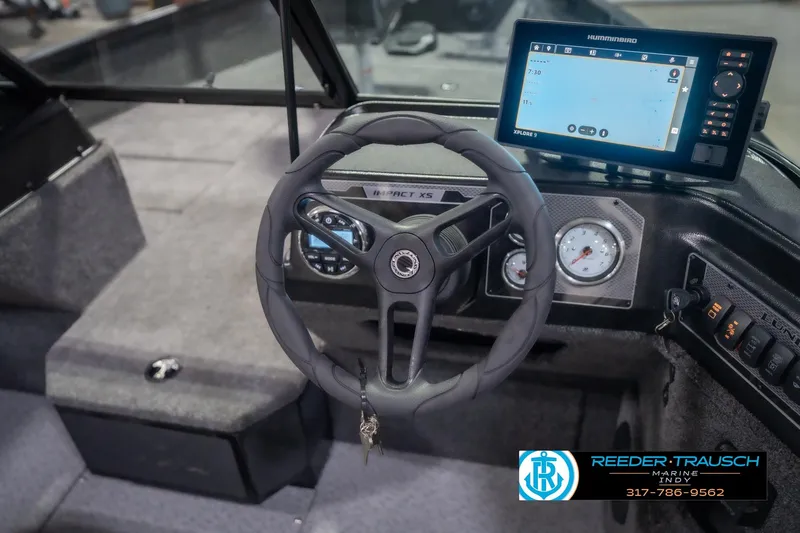 Slide: The Image of 2026 Lund 2075 Impact XS boat dashboard with steering wheel and navigation display. - 32