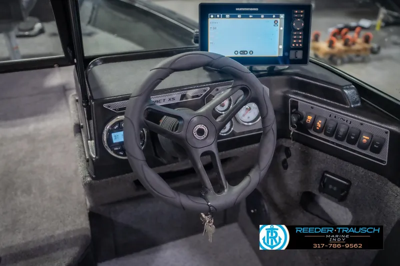 Slide: The Image of 2026 Lund 2075 Impact XS boat dashboard with steering wheel and navigation display. - 33