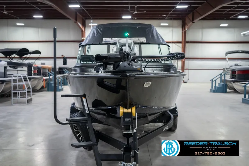 Slide: The Image of 2026 Lund 2075 Impact XS boat in showroom, front view with trailer. - 5