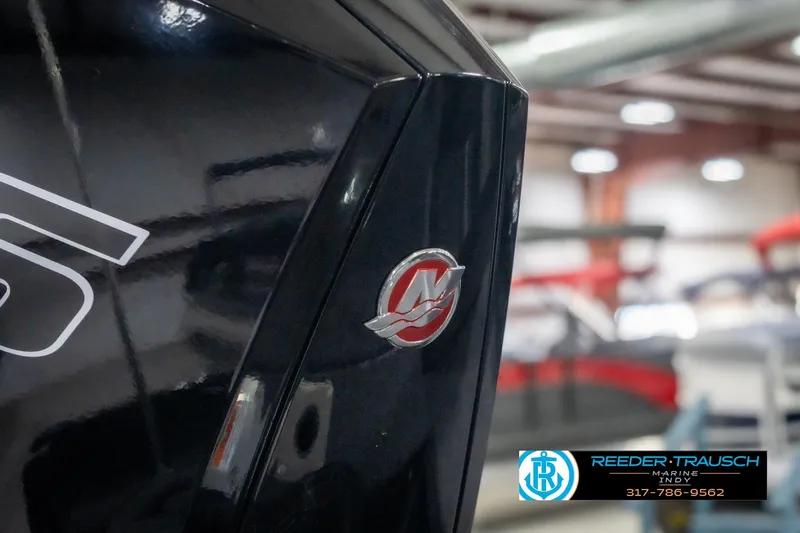 Slide: The Image of 2026 Lund 2075 Impact XS boat detail with logo in showroom setting. - 52