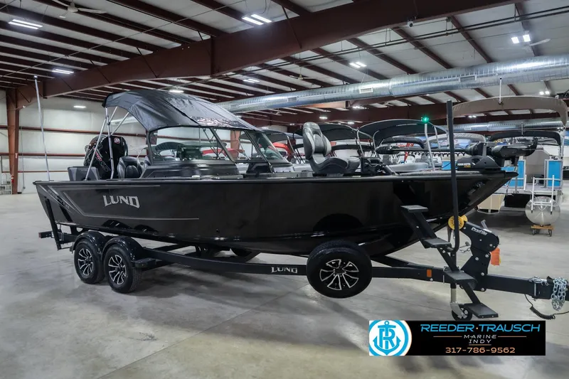 Slide: The Image of 2026 Lund 2075 Impact XS boat in showroom, black exterior, on trailer. - 6