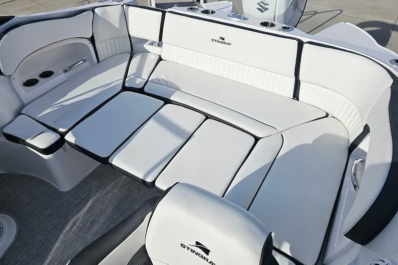 Slide: The Image of 2026 Stingray 211 DC boat interior with white cushioned seating and cup holders. - 14