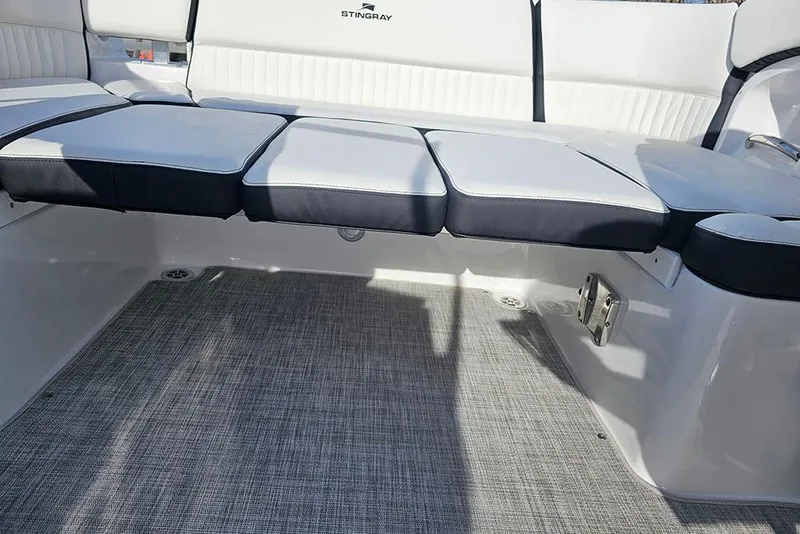Slide: The Image of 2026 Stingray 211 DC boat interior with cushioned seating and textured flooring. - 15