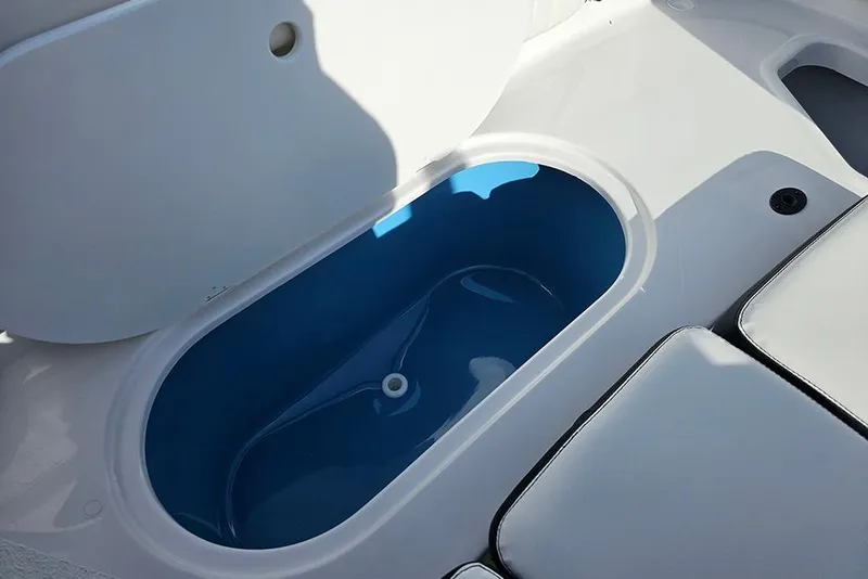Slide: The Image of 2026 Stingray 211 DC boat interior with open storage compartment and seating. - 16