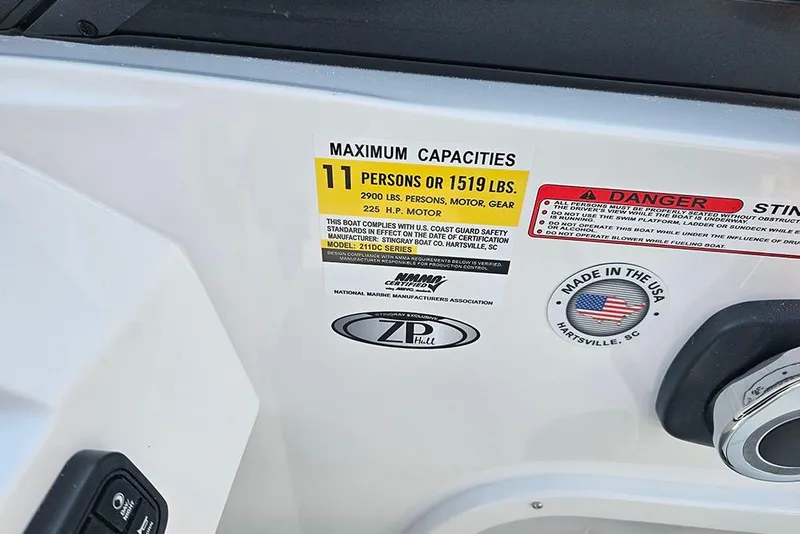 Slide: The Image of 2026 Stingray 211 DC boat capacity label, 11 persons or 1519 lbs, made in USA. - 23
