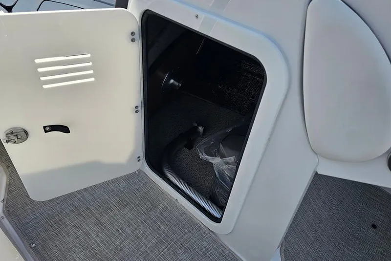 Slide: The Image of Open storage compartment in 2026 Stingray 211 DC boat interior. - 25
