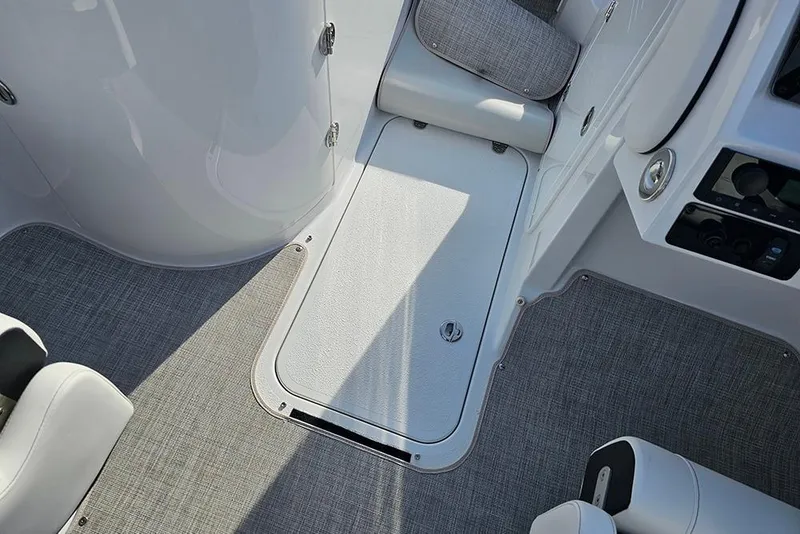 Slide: The Image of 2026 Stingray 211 DC boat interior with gray carpet and seating. - 26