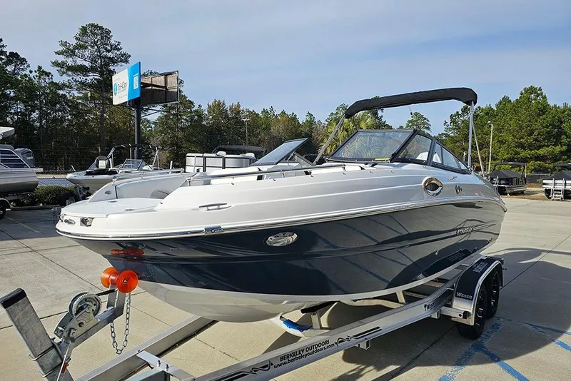 Slide: The Image of 2026 Stingray 211 DC boat on trailer in outdoor dealership setting. - 6