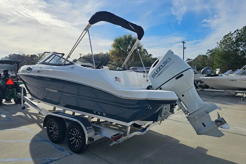 Slide: The Image of 2026 Stingray 211 DC boat with Suzuki outboard motor on trailer. - 8