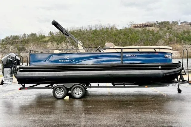 The Image of 2025 Regency 250 DL3 pontoon boat on trailer, parked outdoors. - 0