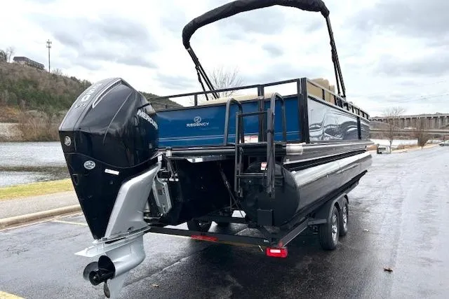 Slide: The Image of 2025 Regency 250 DL3 pontoon boat on trailer, featuring a powerful outboard motor. - 12