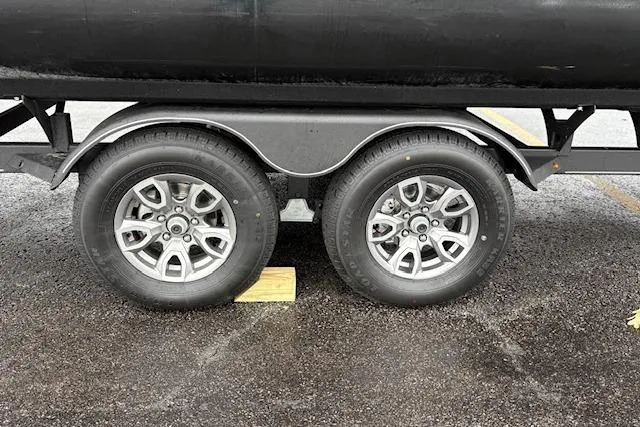 Slide: The Image of Trailer wheels of a 2025 Regency 250 DL3 on wet pavement. - 14