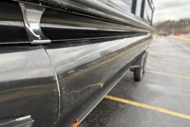 Slide: The Image of 2025 Regency 250 DL3 pontoon boat close-up, showing sleek black exterior in parking lot. - 17