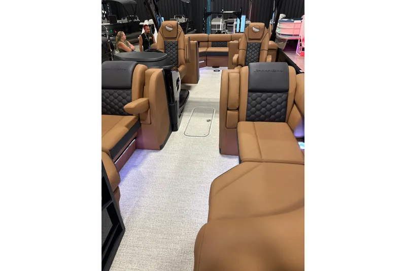 Slide: The Image of 2026 South Bay 525RS pontoon boat displayed indoors on blue flooring. - 3