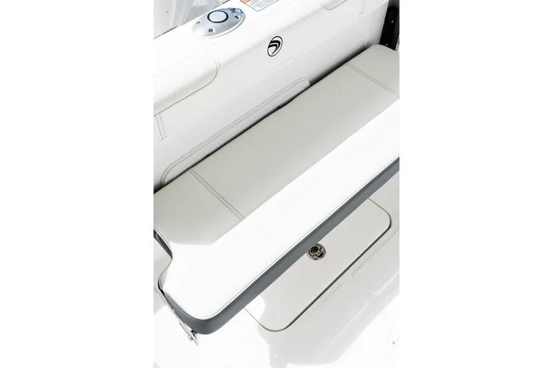Slide: The Image of 2026 Edgewater 230CC boat interior with white cushioned seating and storage compartment. - 14