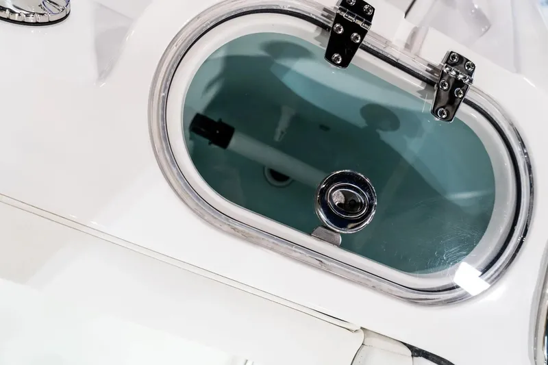 Slide: The Image of 2026 Edgewater 230CC boat livewell with clear lid and secure latches. - 7