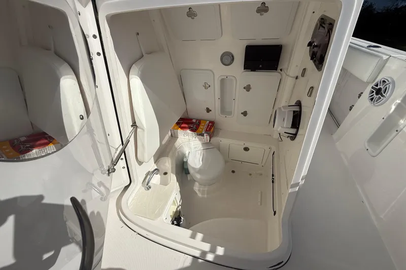 Slide: The Image of 2021 Edgewater 262CC boat interior with compact bathroom and storage compartments. - 10